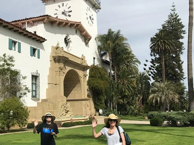 Zwei Frauen winken vor dem Santa Barbara County Courthouse.