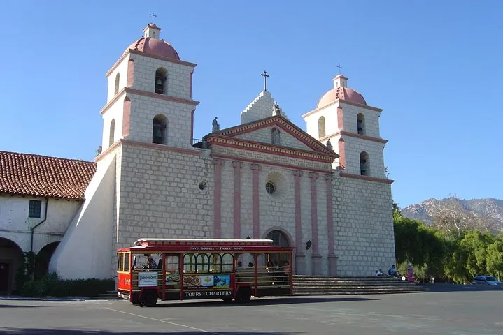 Red trolley parked in front of Old Mission Santa Barbara.