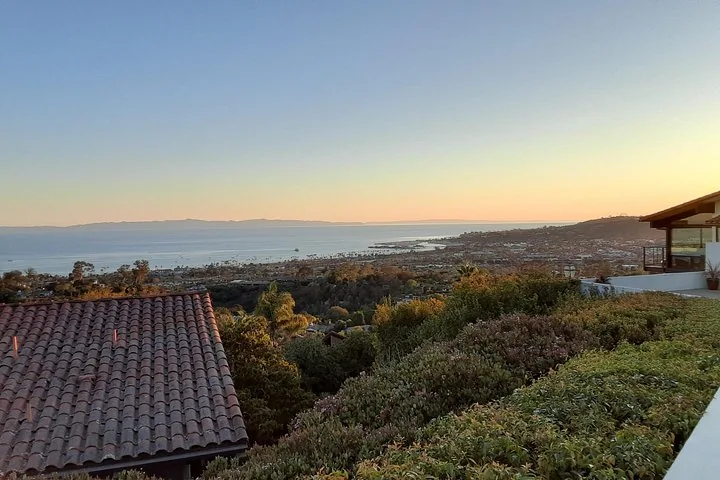 Scenic view overlooking a neighborhood towards the ocean at sunset.